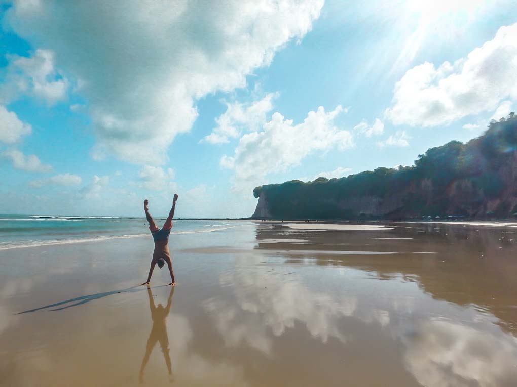 Daniel does a handstand at a beach in Pipa, Brazil