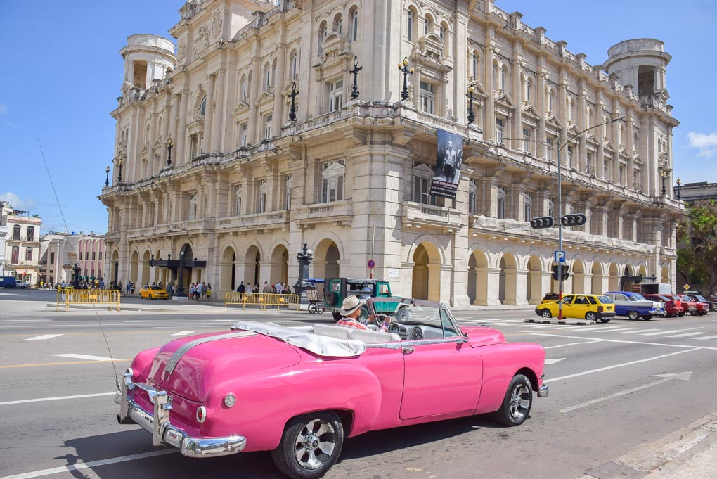 An old car drives through Havana, Cuba while on our backpacking trip