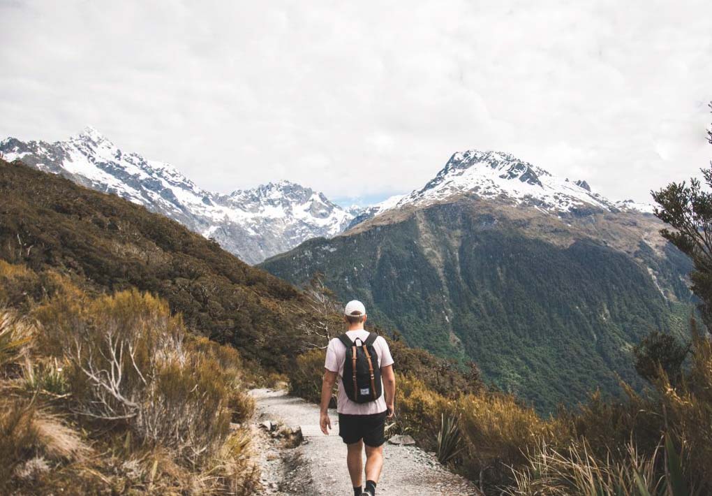 A man walks along the trail of the key Summit on the road to Milford Sound
