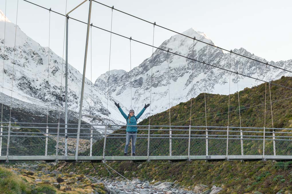 Bailey standing on a suspension bridge on the Hooker Valley Trail with Mount Cook in the background