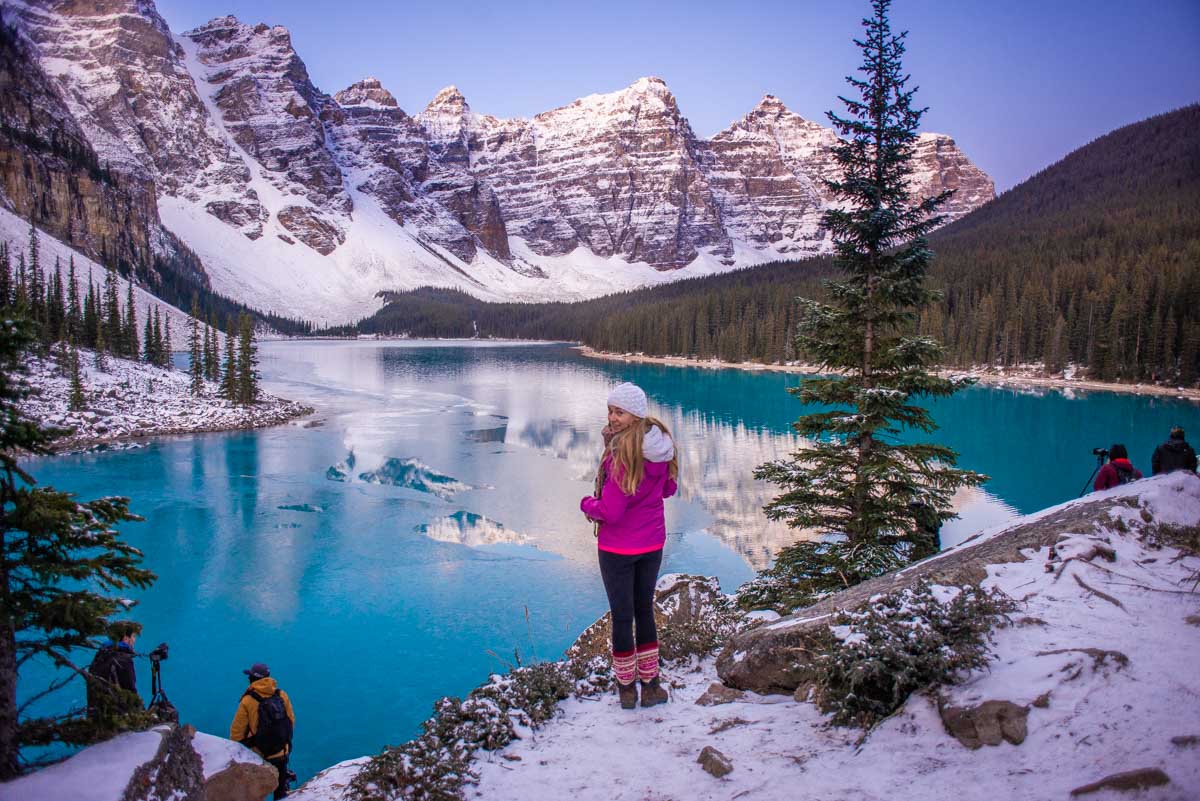 Bailey stands on the edge of Moraine Lake in Banff National Park at sunrise