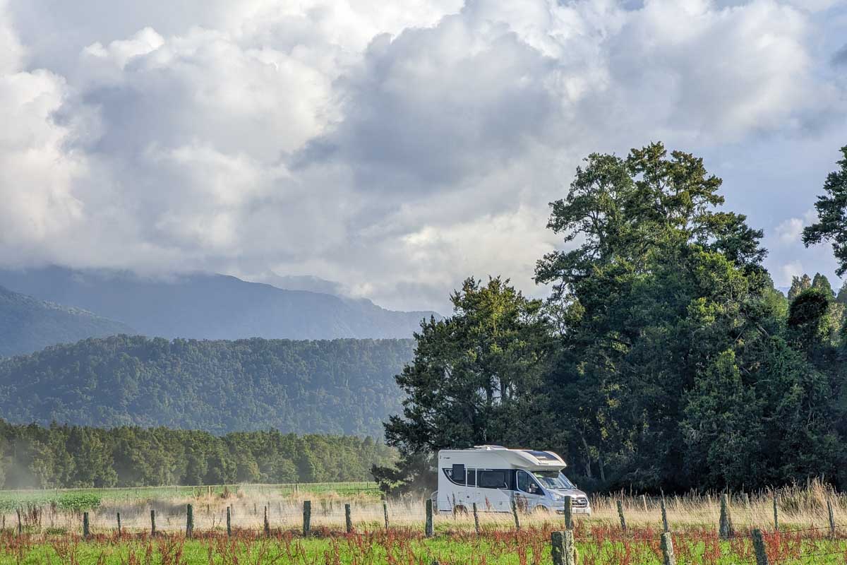 A motorhome drives along a remote road near fox Glacier, New Zealand