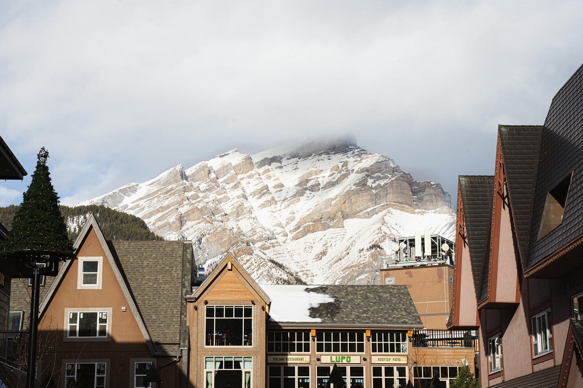 the outside of Base Camp suites in Banff with Rundle Mountain behind it