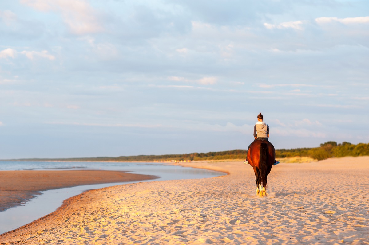 woman rides a horse on a beach not far from Puerto Escondido