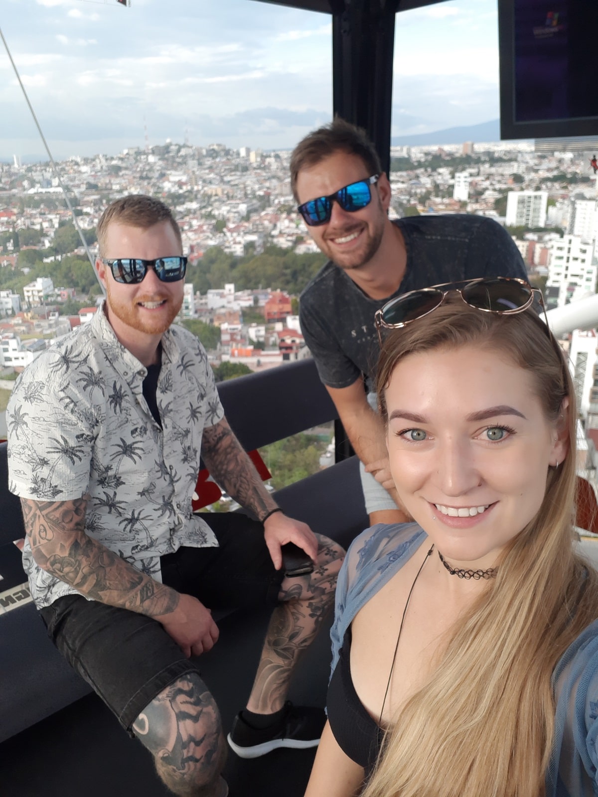 three people take a selfie on the ferris wheel in Puebla, Mexico