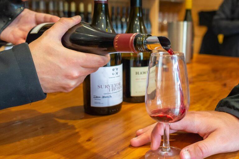 Pouring wine into a glass at a Queenstown winery