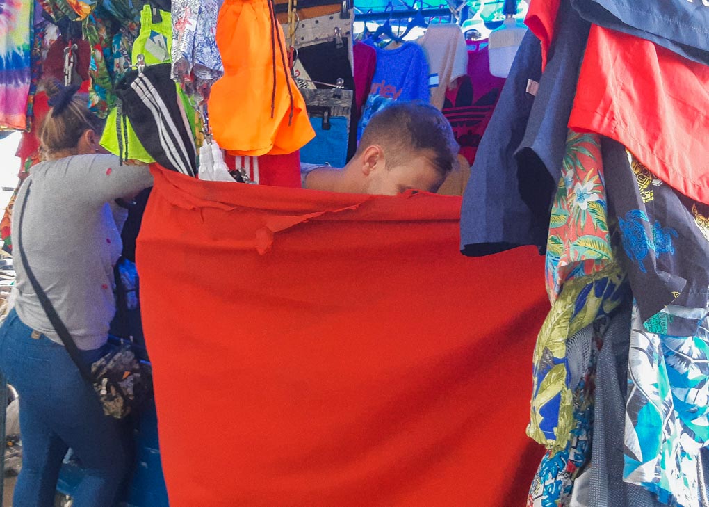 Daniel changes in a makeshift cvhangeroom at the street markets of Santa Marta