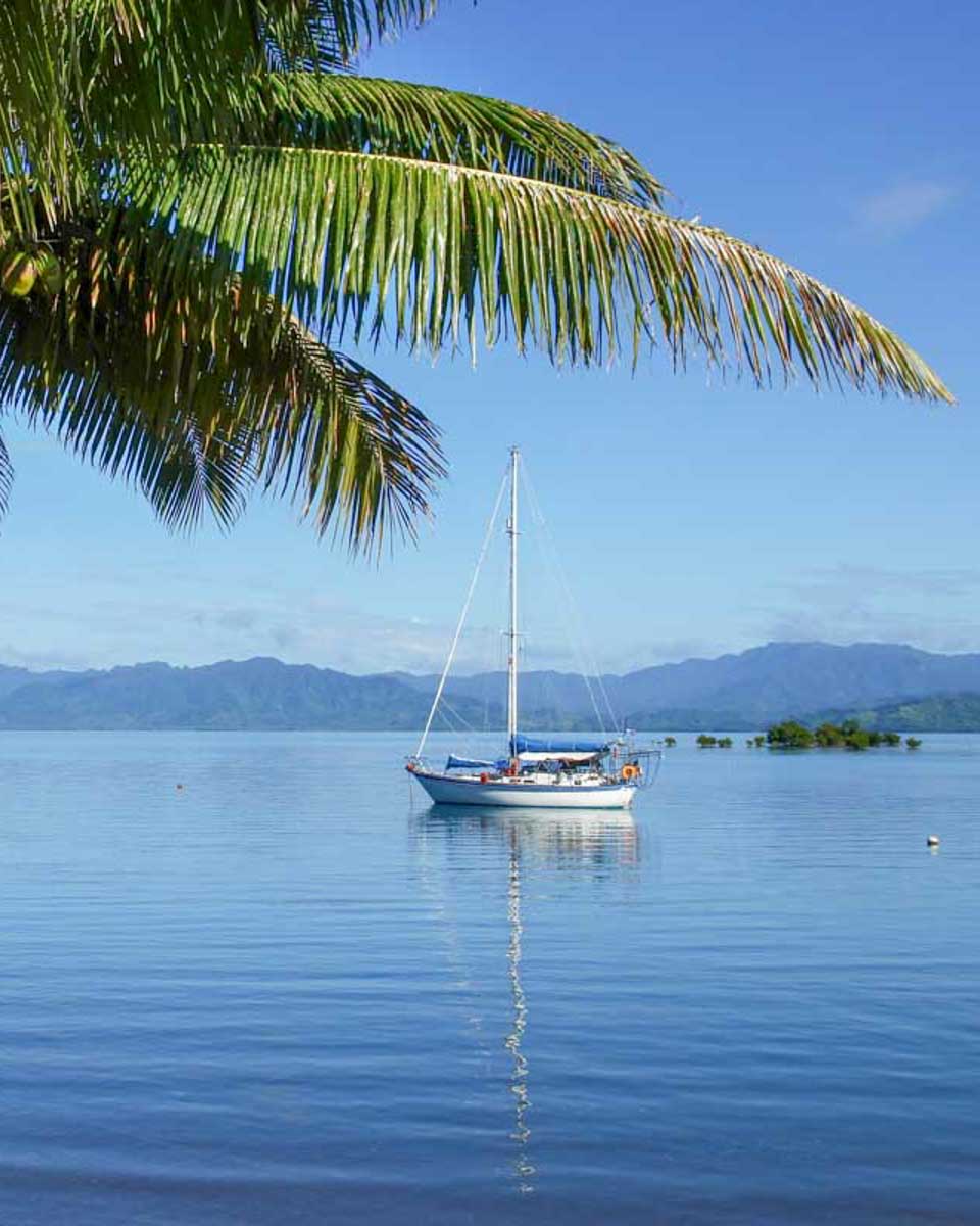 A-boat-anchored-off-an-island-in-Fiji-on-a-multi-day-cruise