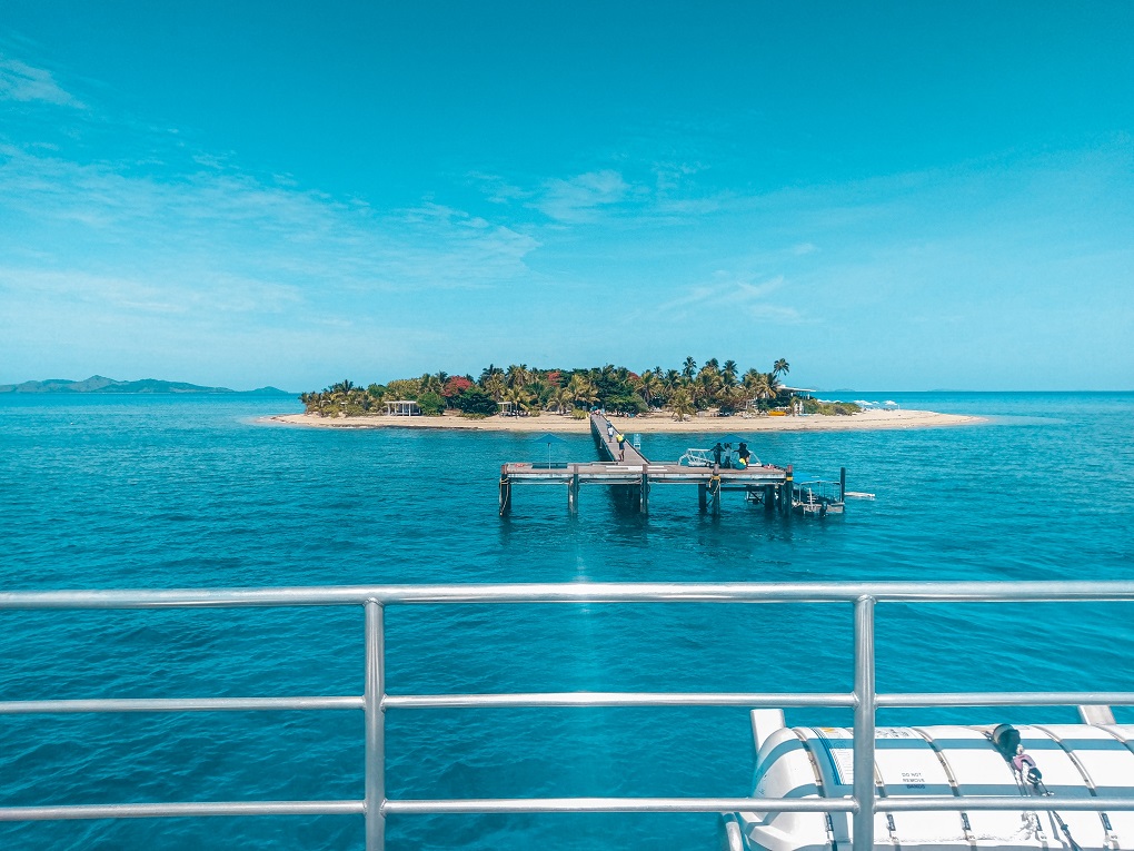 view from a boat railing arriving at a remote island in fiji