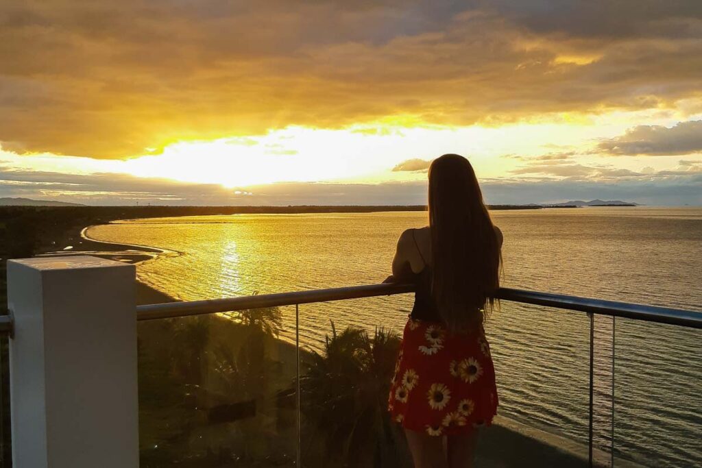 lady stands at a rooftop bar at sunset in Nadi, Fiji