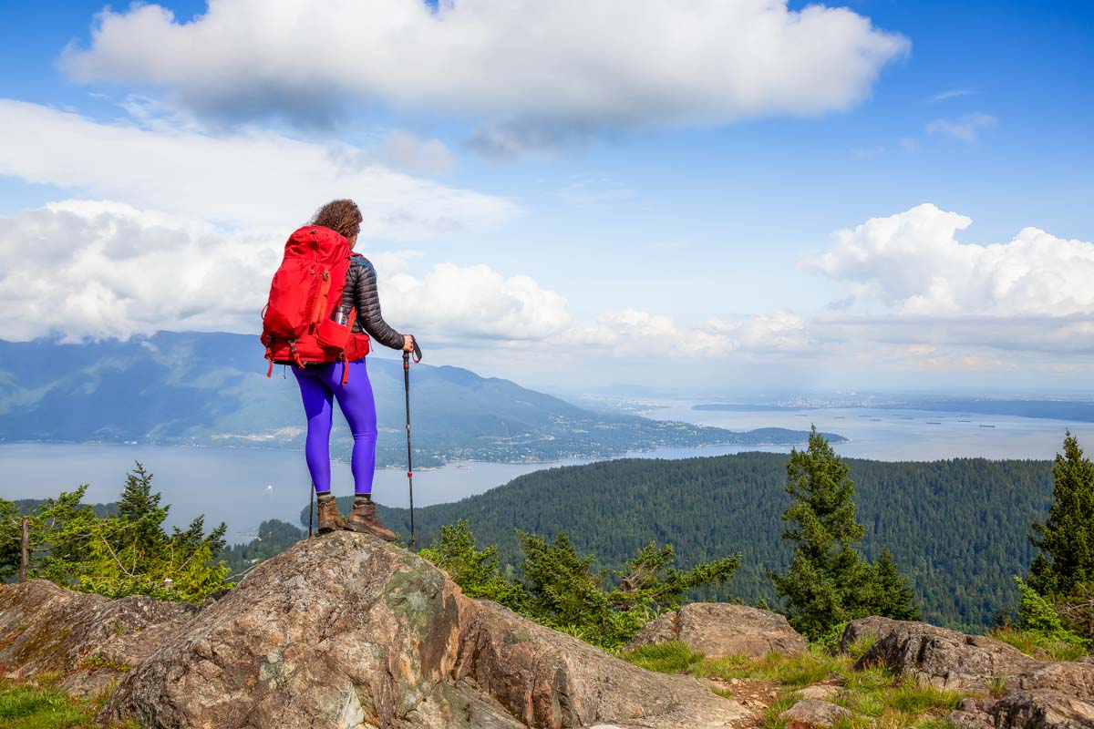 A lady stands at the top of Mt. Gardner summit on Bowen Island, British Columbia