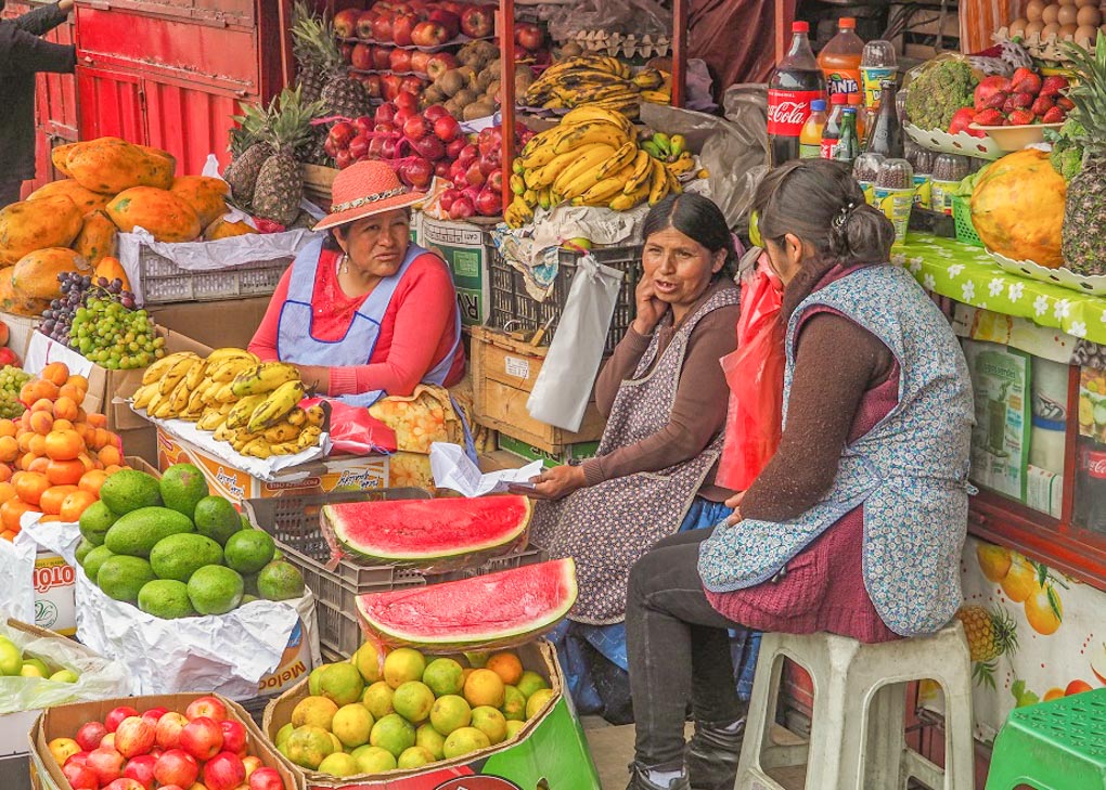Two ladies sit at a market stall in Bolivia