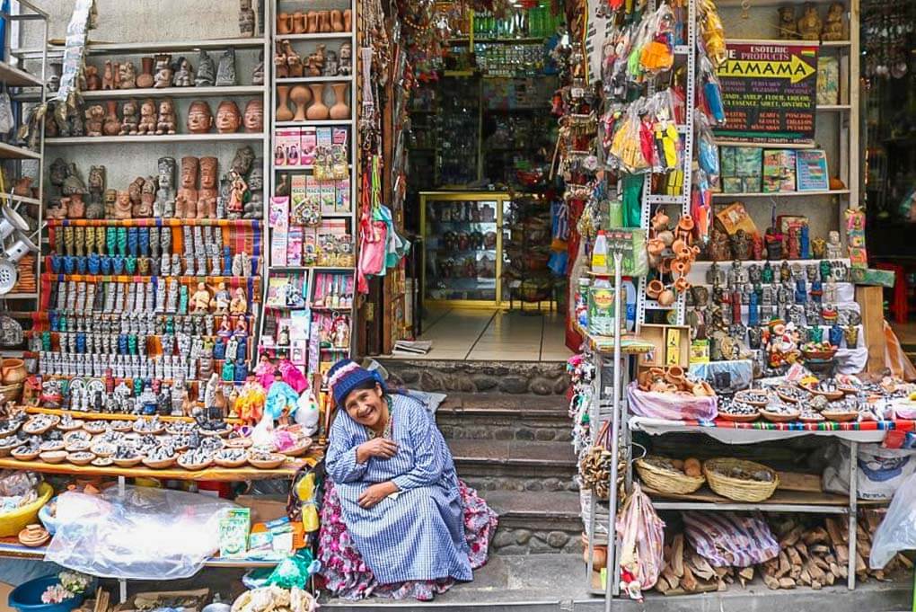 A lady sits out the fron of here shop in the Witches Market in La Paz