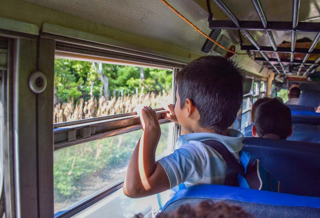A boy rides a chicken bus in Central America