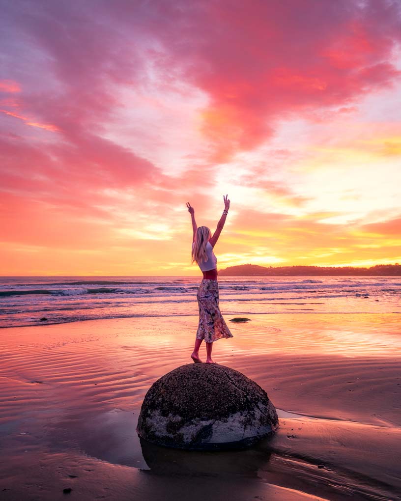 standing ona rock at the Moeraki Boulders at sunrise, New Zealand