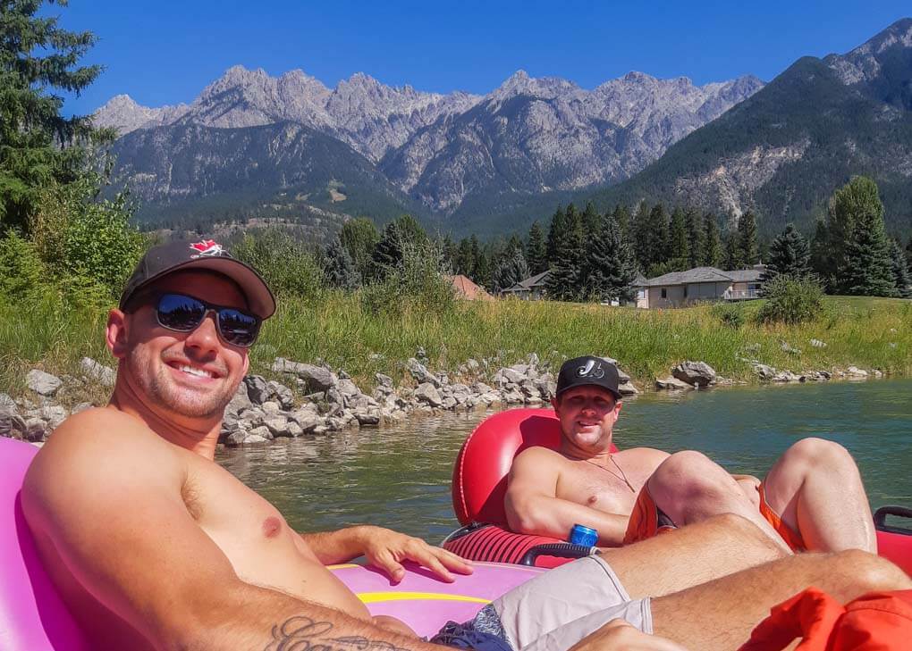 Two people relax in inflatable tubes on the Columbia River float near Invermere,BC