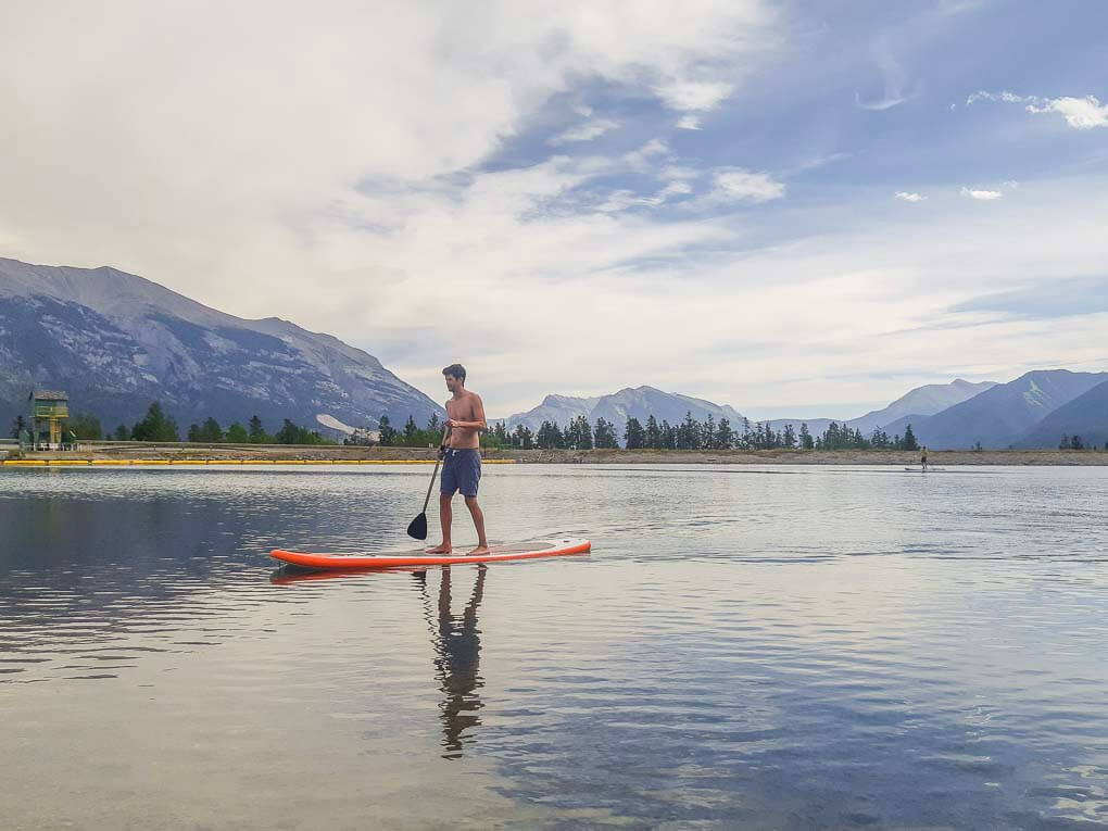 A man paddleboards at Rundle Forebay Reservoir in Canmore