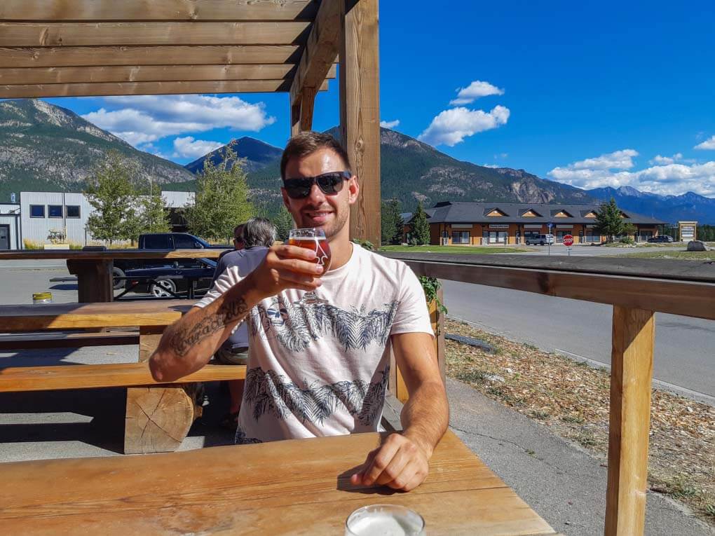 A man enjoys a beer at Arrowhead Brewing in Invermere, BC