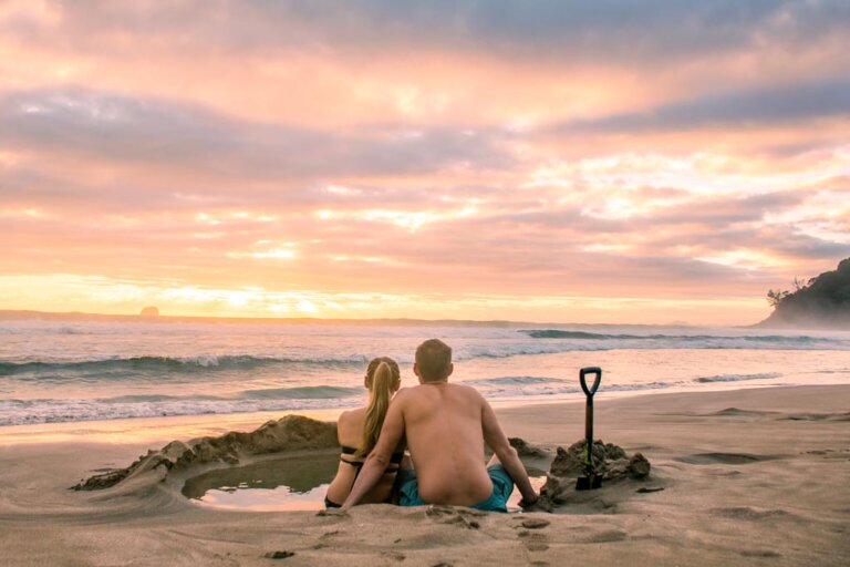 A couple relax at Hot Water beach in New Zealand