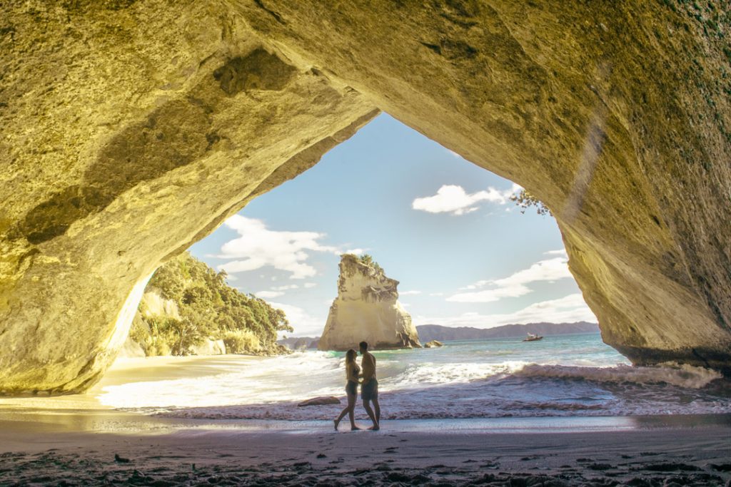 couple in cathedral cove, new zealand
