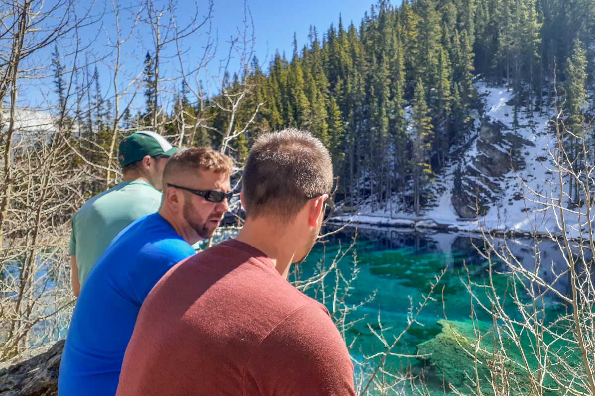 Daniel and two friends sit at Grassi lakes in Canmore while there is still snow on the ground