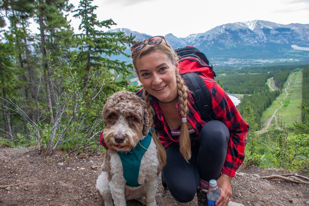 A lady poses for a photo wiht a dog on the Grassi Lakes Trail