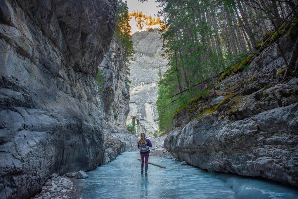 A lady walsk through Grotto canyon in winter in Canmore