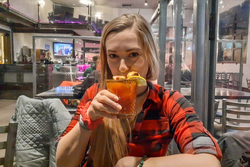 A lady drinks a cocktail at Blake Brewhouse and Distillery
