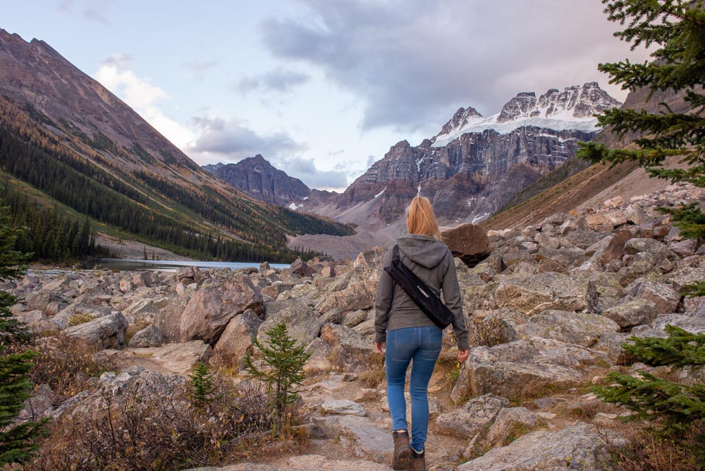 A lady hiking on the trail with the lakes in front of her