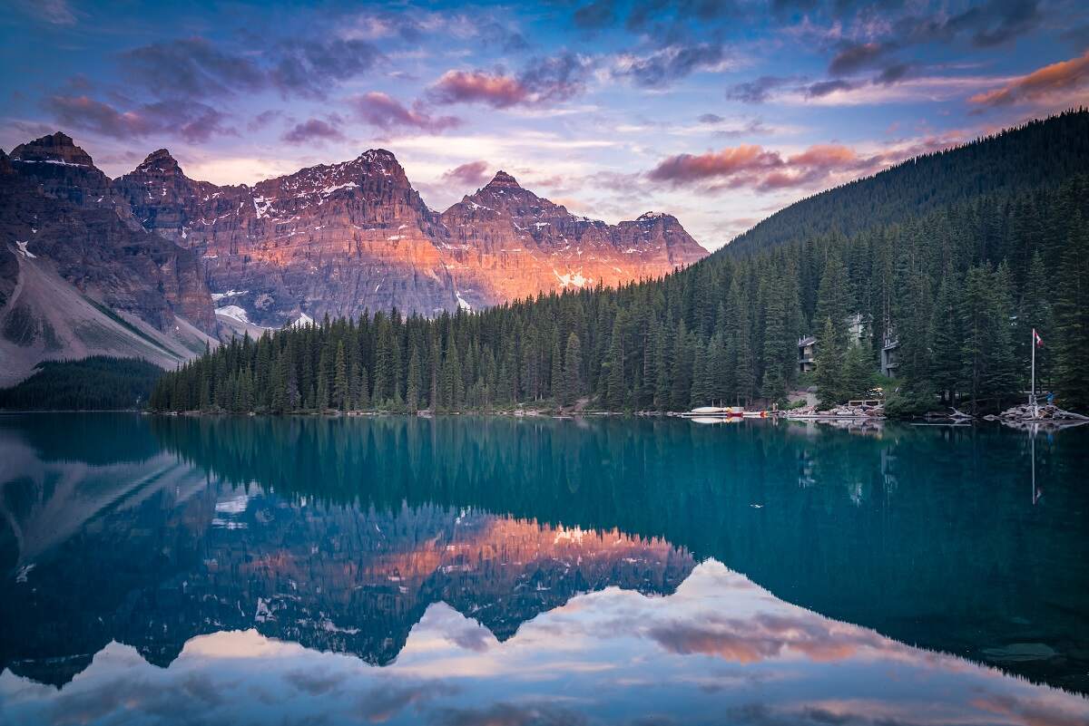 view of mountains reflecting on Moraine Lake at sunset