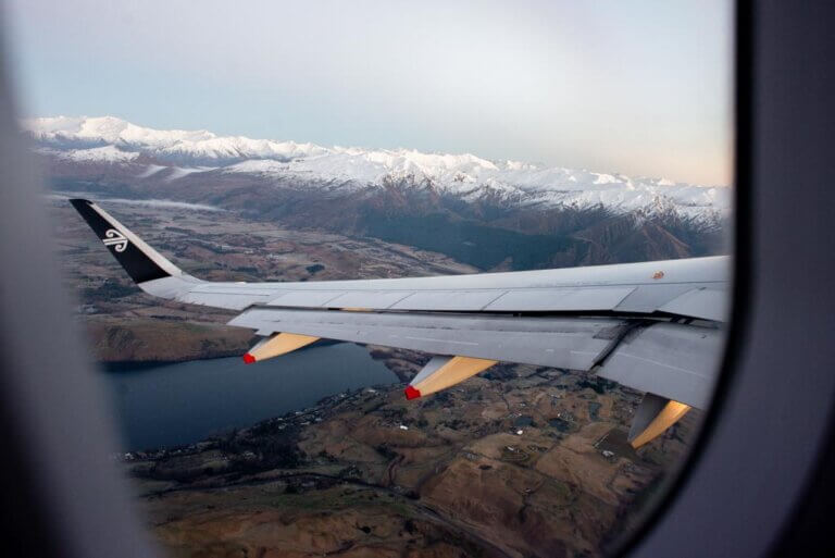 A plane flys over the mountains on a long haul international flight