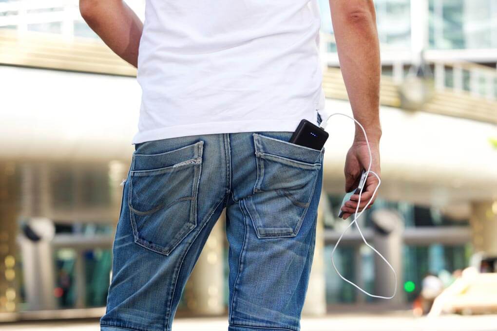 A man with a battery pack that's charging his phone