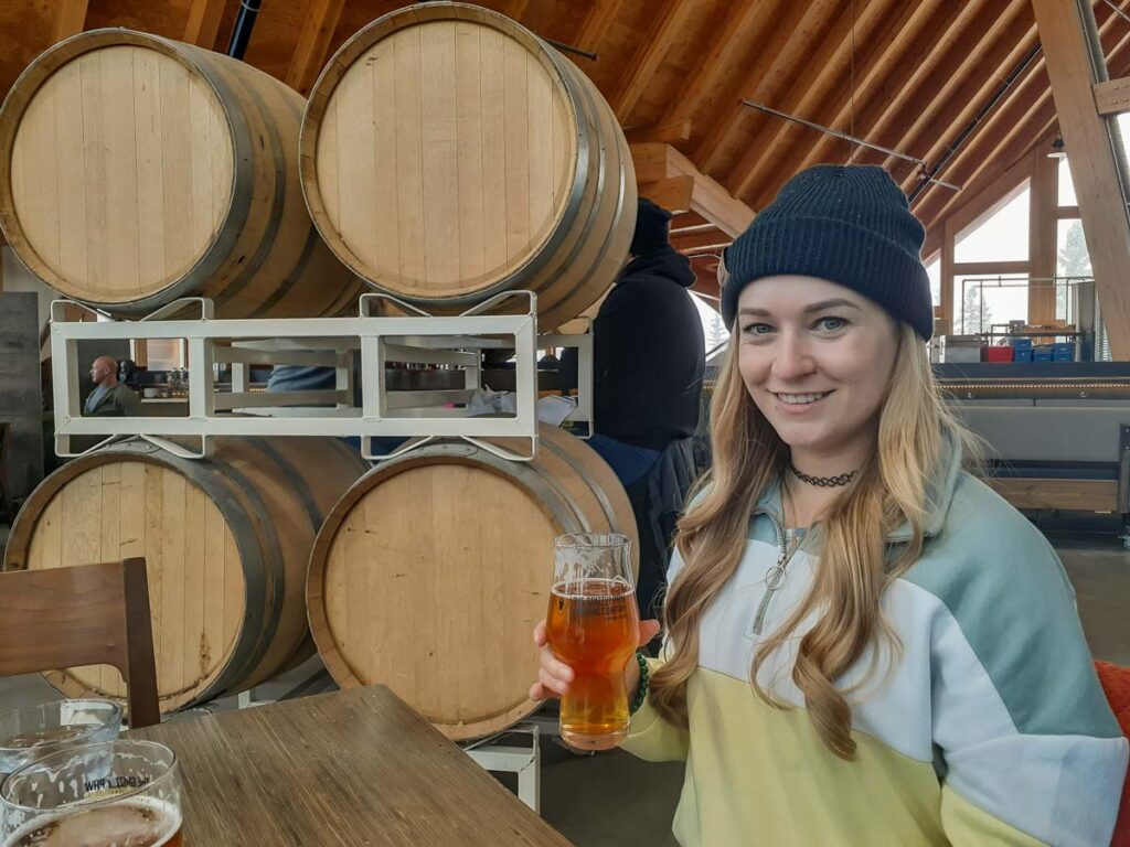 girl drinking beer at the Girzzly Paw in Canmore in winter