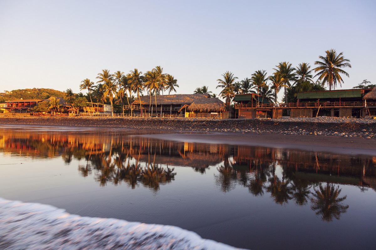 beach at sunset with reflection in the sand at El Tunco, El Salvador