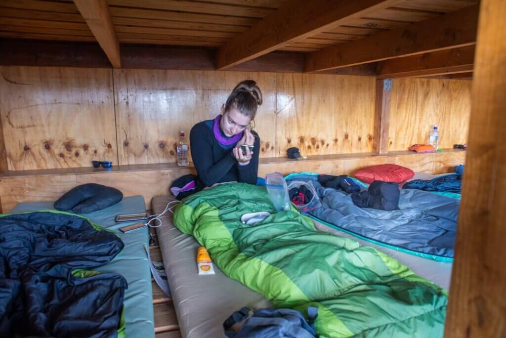 woman in a sleeping bag in a bunk bed withing a new zealand hut