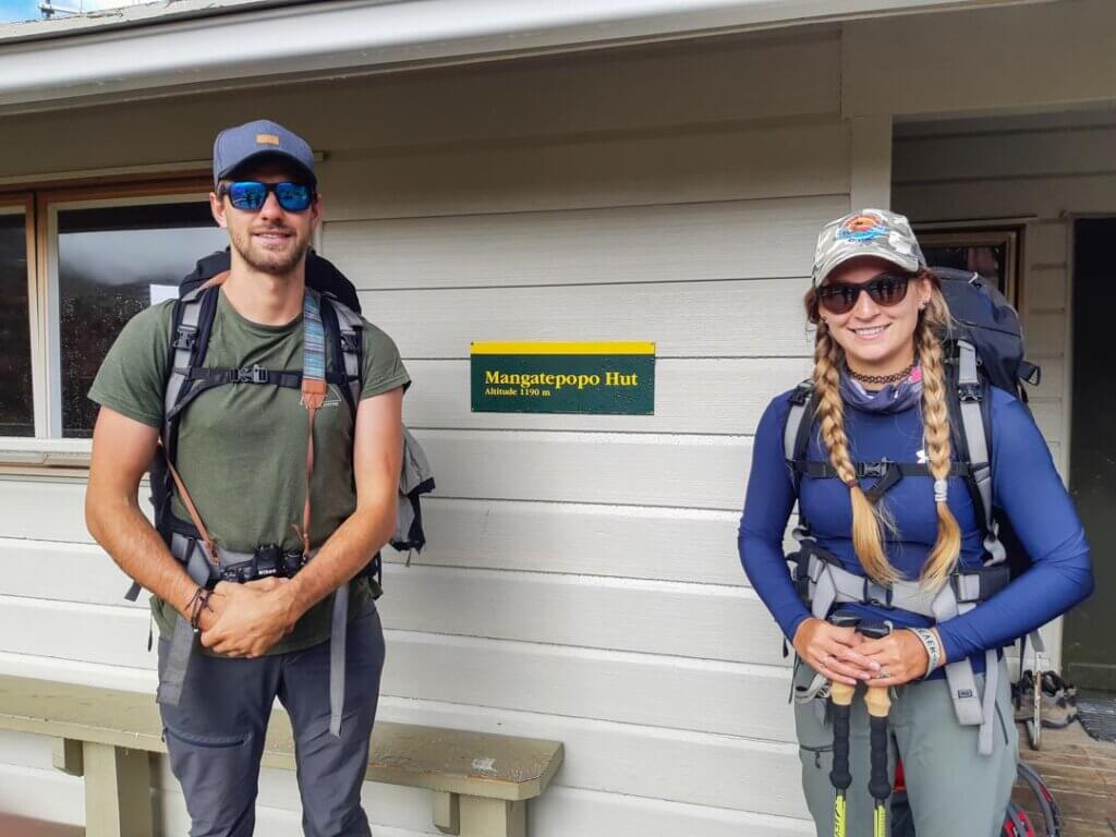 two people standing outside a hut in New Zealand