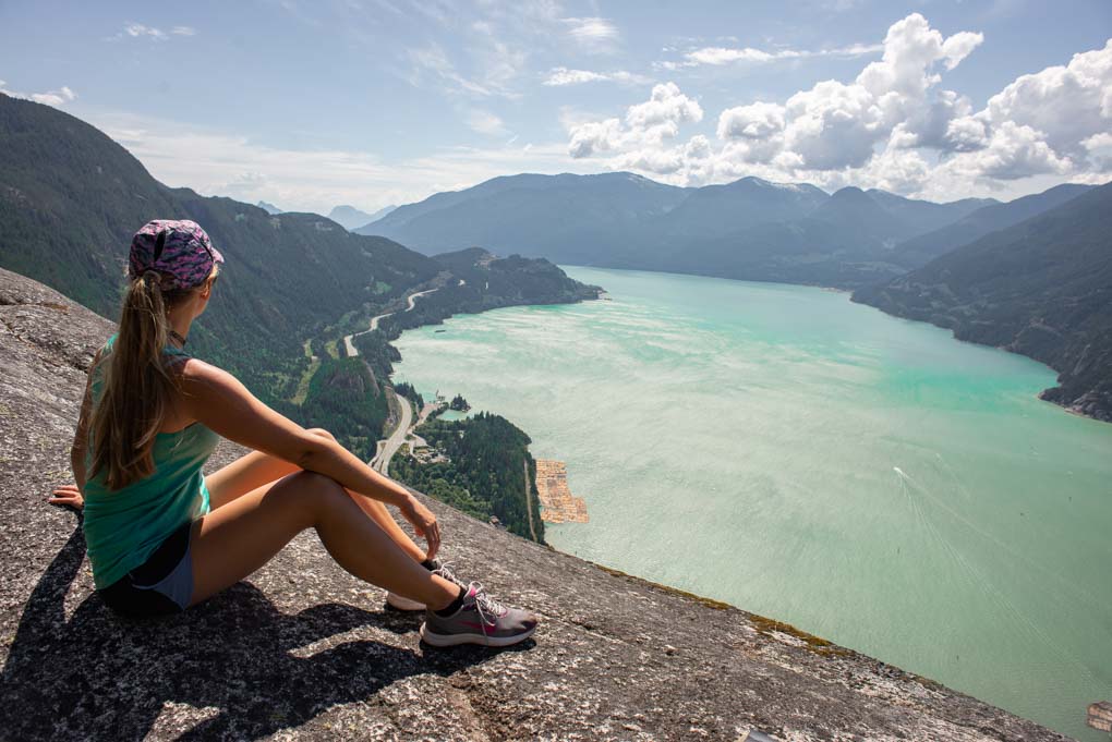 A lade sits at the top of the Stawamus Chief hike near Vancouver, Canada
