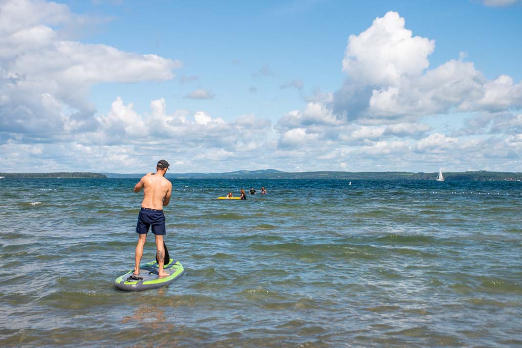 Man paddleboarding out on Sylvan Lake, Alberta