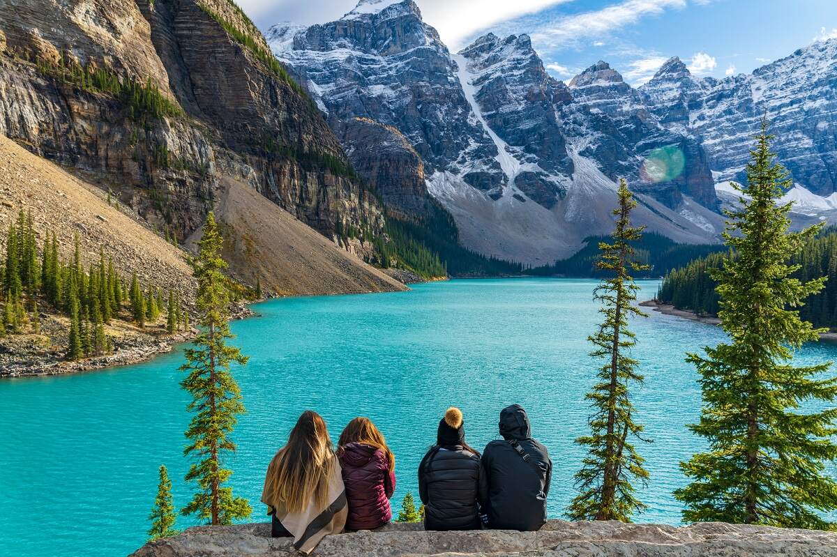 four people enjoying a picnice with a view of MoraineLake