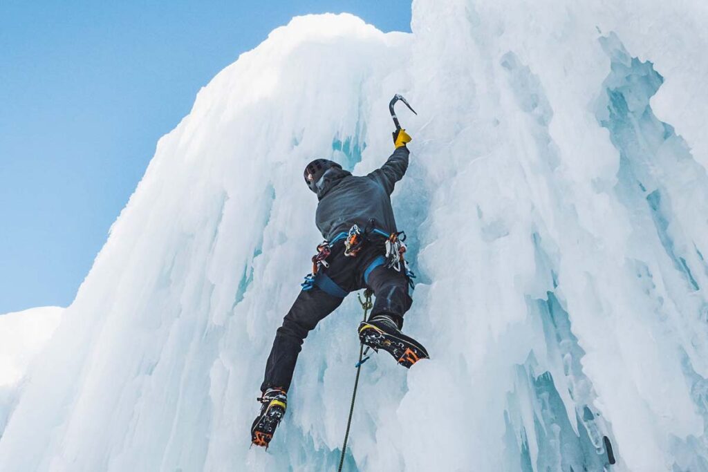 An ice climber climbs a frozen waterfall in Golden, BC