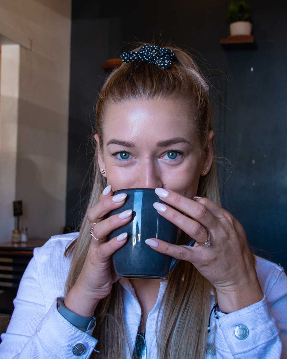 Bailey holds a big mug of coffee to drink