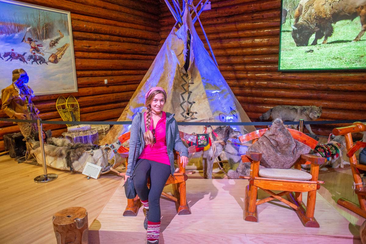 A lady poses for a photo with a display at the Buffalo Nations Museum, Banff