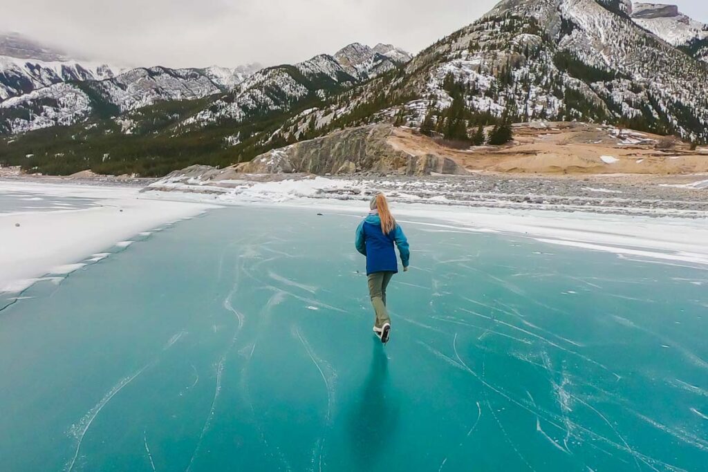 A lady ice skates on a frozen lake