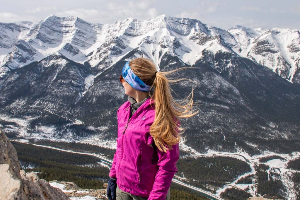 Bailey stands on a mountain in essential gear for the Canadian Rockies