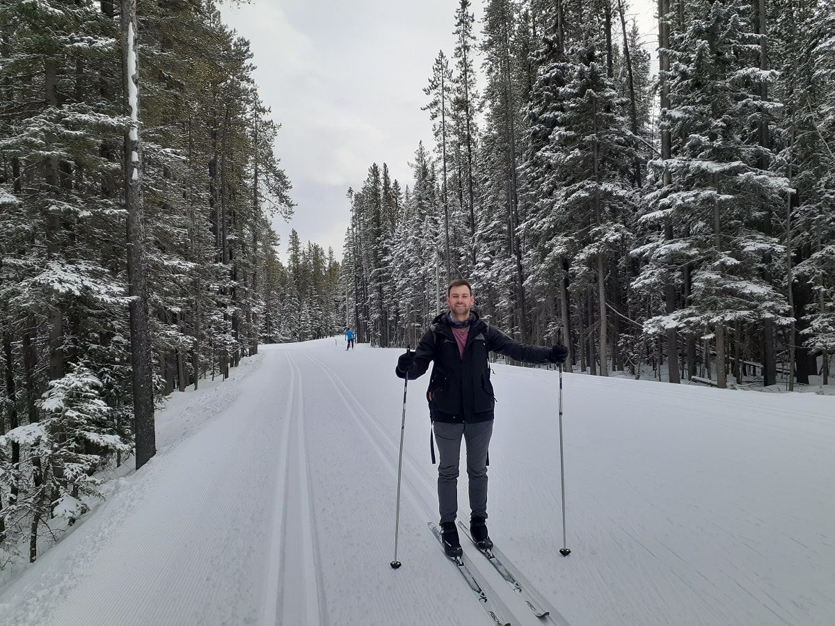 Daniel cross country skiing among pine trees in Canada