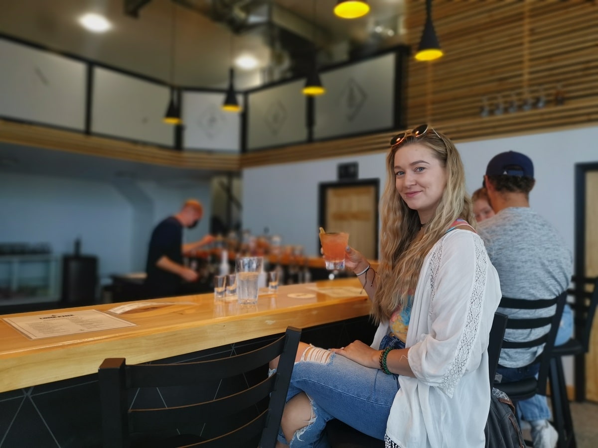woman sitting at a distillery bar in Edmonton, Alberta
