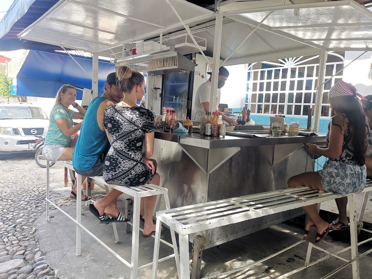 group of friends eating at a fish taco stand in Puerto Vallarta