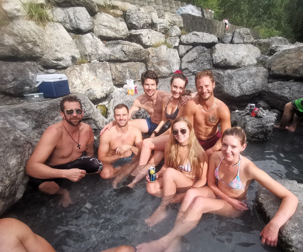 group of people sitting in the lussier hot springs - one of the best things to do in Fairmont, BC