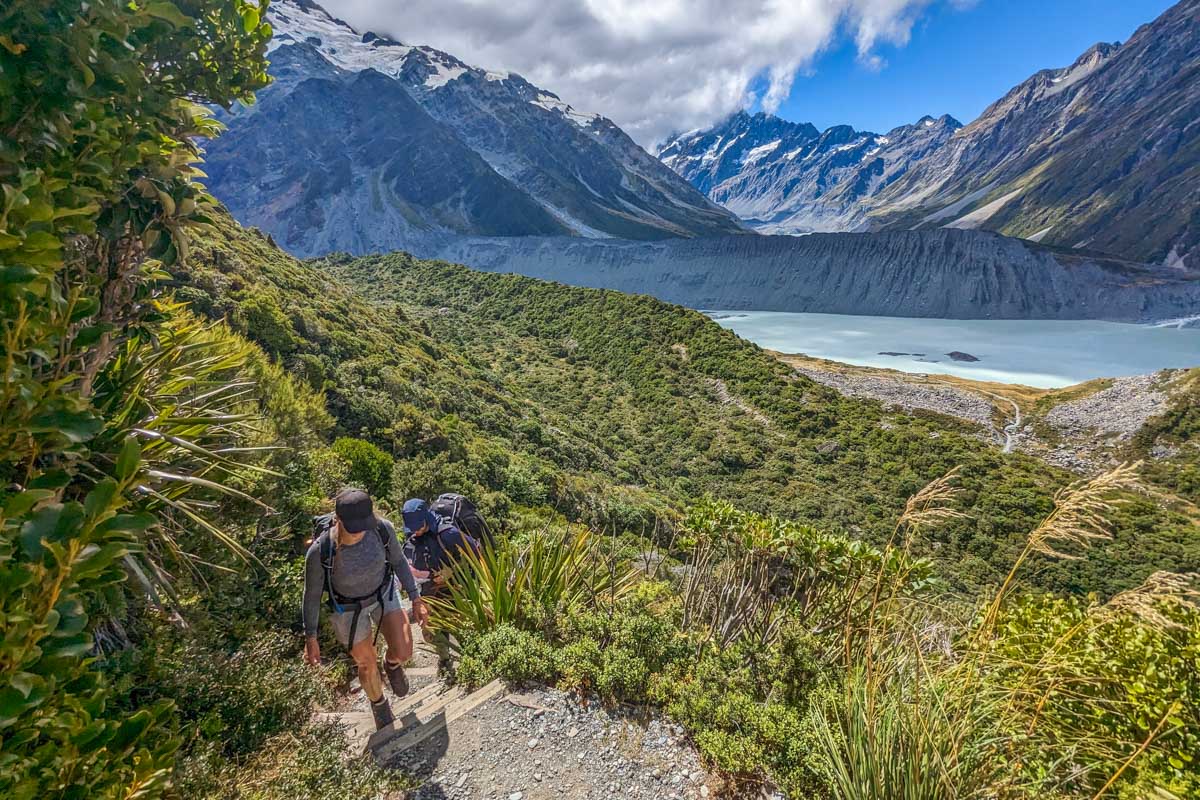 A group of hikers climb the Sealy Tarns Trail towards the Mueller Hut
