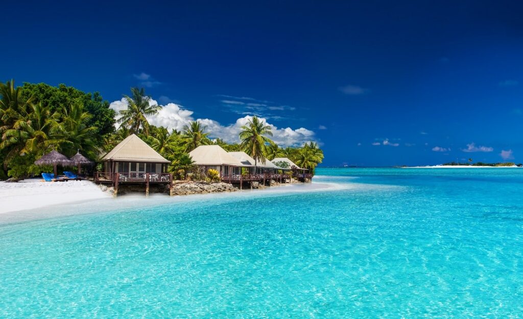 oceanfront traditional bures on a white sandy island in Fiji
